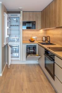einen offenen Kühlschrank in einer Küche mit Holzschränken in der Unterkunft Siili Apartment-free parking in Tartu