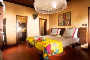 - une chambre avec un lit doté d'une couverture jaune dans l'établissement Villas de Vohilava, sur l'île Sainte-Marie