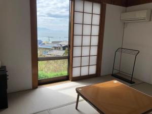 笠岡市にある白石島国際交流ヴィラのテーブルと大きな窓が備わる客室です。