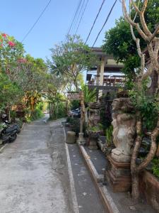 a street with a bunch of trees in front of a building at Kubu Loris Residence in Ubud