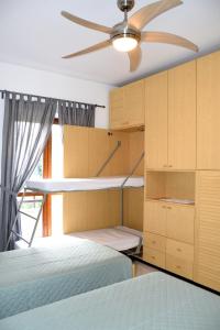 een slaapkamer met 2 bedden en een plafondventilator bij La Luna sul lago in Trevignano Romano