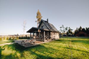 ein kleines Haus auf einem Feld mit einem Picknicktisch in der Unterkunft Dzerkaļi in Cirma