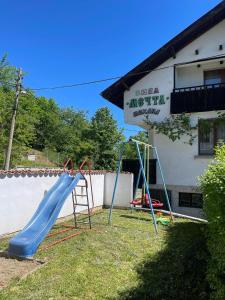a playground in front of a building with a slide at Вила Мечта in Tryavna