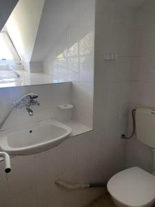 a white bathroom with a sink and a toilet at Вила Мечта in Tryavna