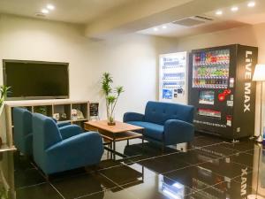 une salle d'attente avec des chaises bleues et une télévision dans l'établissement HOTEL LiVEMAX Yokkaichi Ekimae, à Yokkaichi