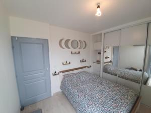 1 dormitorio con cama, puerta y espejo en Terrasse 130m2 panoramique avec Climatisation Piscine - 3 chambres, en Gréoux-les-Bains