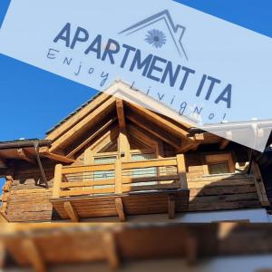 een model van een houten huis met de woorden appartement itaagencyagency bij Apartment Ita in Livigno