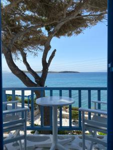 a table and chairs on a balcony overlooking the ocean at Nissiotiko Hotel in Drios