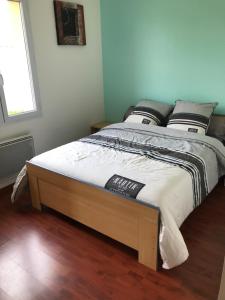 1 cama con marco de madera en un dormitorio en Belle Maison au calme 4 à 6 pers. 25mn Futuroscope en Vivonne