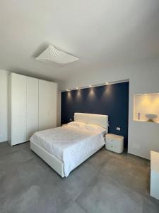 1 dormitorio con cama blanca y pared azul en Luxury Sea House, en Trapani