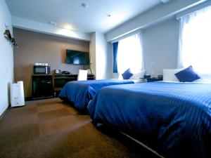 Postel nebo postele na pokoji v ubytování HOTEL LiVEMAX Kasai Ekimae