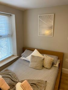 a bedroom with a bed with pillows and a window at 'Bloomfield' at stayBOOM in Lancaster