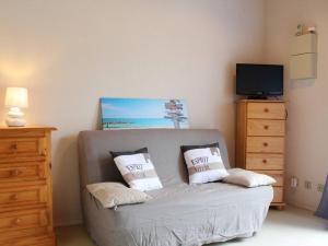 een woonkamer met een bank met twee kussens erop bij Appart 2 pièces proche plage Dolus-d'Oléron - FR-1-246A-1 in Dolus d'Oléron