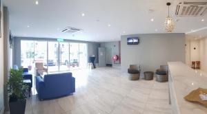 a lobby of a store with blue chairs and a counter at HOTEL ORKID PORT KLANG in Klang