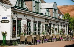 uma fila de cadeiras sentadas fora de um edifício em Boutique-Hotel Zur alten Post - Stammhaus em Büsum