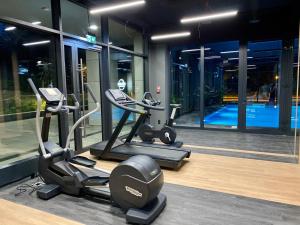 une salle de sport avec des appareils de cardio-training et une piscine dans l'établissement Easy Rent Apartments - City Rest, à Lublin