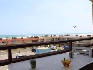 - une table sur un balcon avec vue sur la plage dans l'établissement Appartement Port-la-Nouvelle, 2 pièces, 4 personnes - FR-1-229C-338, à Port-la-Nouvelle