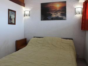 - une chambre avec un lit et deux lumières sur le mur dans l'établissement Appartement Port-la-Nouvelle, 2 pièces, 4 personnes - FR-1-229C-338, à Port-la-Nouvelle