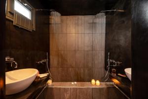 a bathroom with a tub and a sink at Saint Sin Suites - Adults Only in Imerovigli