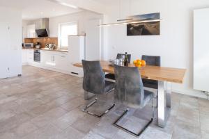 uma cozinha com uma mesa de madeira e cadeiras em Haus Ran Ferienwohnung Ran 1 em Wittdün