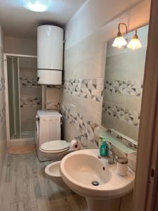 a bathroom with a sink and a toilet and a mirror at MARIS Apartments & Bedrooms in Alghero