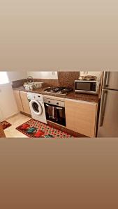 cocina con fogones y lavavajillas en Magnifique Appartement balnéaire à Bouznika avec piscine, en Bouznika