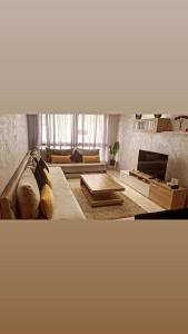 a living room with a couch and a table at Appartement magnifique avec 3 piscines,à proximité de la plage in Bouznika