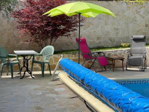 - une piscine avec des chaises, une table et un parasol dans l'établissement Gite les Bleuets, à Saze