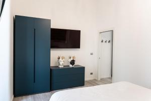 a bedroom with a blue cabinet and a tv at Il Moro Boutique Apartment in Catania