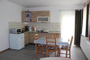 cocina con mesa y sillas y cocina pequeña con mesa en Otto Apartment, en Harkány