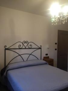 a bedroom with a bed and a chandelier at AFFITTACAMERE POGGIGRILLI in Pievepelago