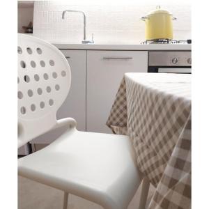 une chaise blanche assise à côté d'une table dans la cuisine dans l'établissement Casa Sole Mare, à Castellammare del Golfo