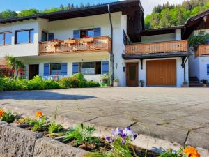 ein Haus mit einer Auffahrt und Blumen in der Unterkunft Haus Angerbichl in Ramsau bei Berchtesgaden