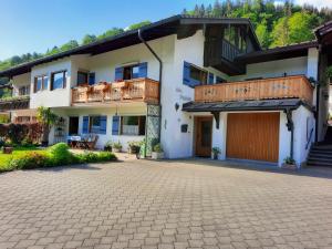 ein Haus mit einer Terrasse und einer Auffahrt in der Unterkunft Haus Angerbichl in Ramsau bei Berchtesgaden