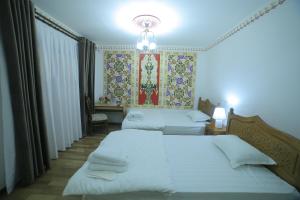 A bed or beds in a room at Bukhara Baraka Boutique Hotel