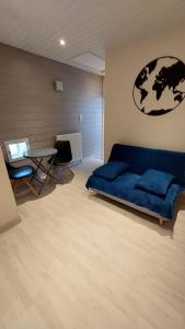 - un salon avec un canapé bleu et une table dans l'établissement Chez Madgi et Jean-Mi, à Froncles