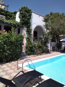 una piscina con sillas junto a una casa en Studios Irineos, en Perissa