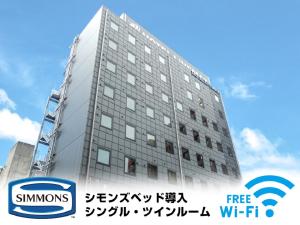 wysoki budynek z znakiem przed nim w obiekcie HOTEL LiVEMAX Numazu Ekimae w mieście Saint Neots