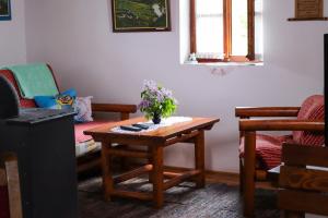 ein Wohnzimmer mit einem Tisch mit Blumen darauf in der Unterkunft Apartment ''Planinsko selo'' in Zaovine