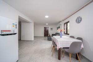 a kitchen and dining room with a table and chairs at Organic Garden Apartment in Risan