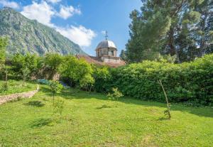 a garden with a building in the background at Organic Garden Apartment in Risan