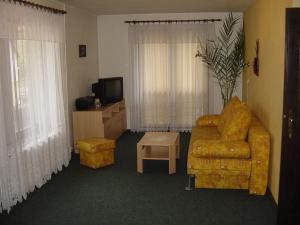 a living room with a couch and a tv at Penzion v Budech in Křivoklát