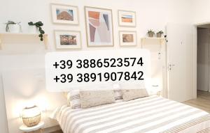 una camera bianca con un letto con una coperta a righe di SUITE BLANC APARTMENTS - Monolocali indipendenti con cucina e bagno privato - Check-in e check-out con codice in autonomia h24 - Terrazza in comune a Guspini