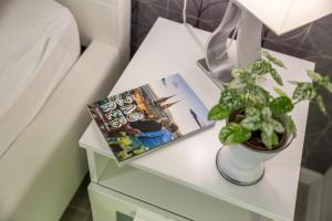 a table with a book and a plant on it at RIKI'S APARTMENT-ZAGREB in Zagreb