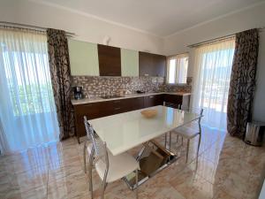 kuchnia z białym stołem i krzesłami w obiekcie Oasis Villa - Maisonette A w mieście Almirón