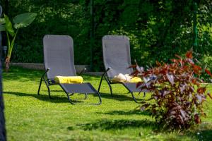 two chairs sitting in the grass in a yard at RIKI'S APARTMENT-ZAGREB in Zagreb