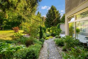 un giardino con sentiero in pietra di fronte a una casa di RIKI'S APARTMENT-ZAGREB a Zagabria