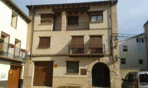 ein altes Gebäude mit Fenstern und Balkonen auf einer Straße in der Unterkunft B&B Ra Tenaja in Castillazuelo