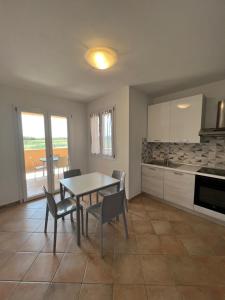 a kitchen with a table and chairs in a room at MARIS Apartments & Bedrooms in Alghero
