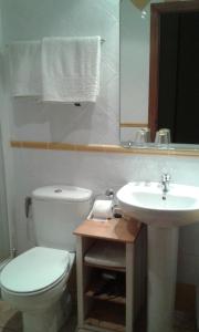 a bathroom with a white toilet and a sink at B&B Ra Tenaja in Castillazuelo
